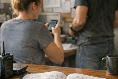 Restaurant manager reviewing schedule while employee speaks in office