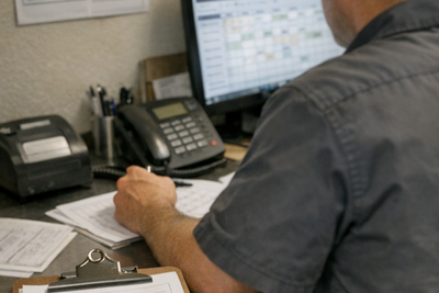 Restaurant manager reviewing staff schedule in busy kitchen office